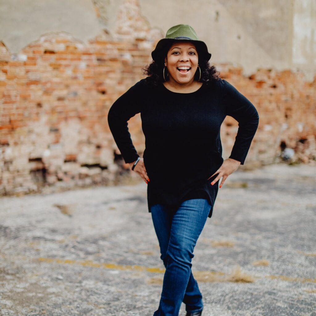 Ronnika smiling in front of a concrete wall