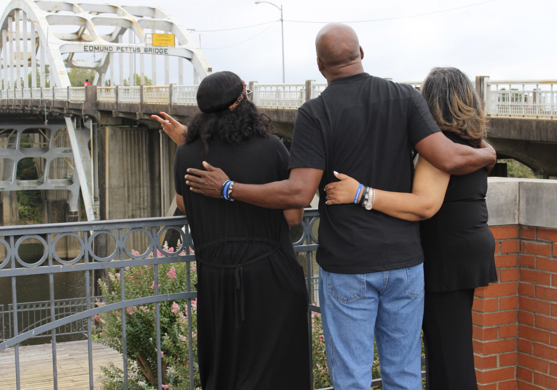 Ronnika embracing two of her colleagues, overlooking the city.